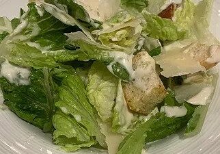 A fresh Caesar salad with creamy dressing and croutons.